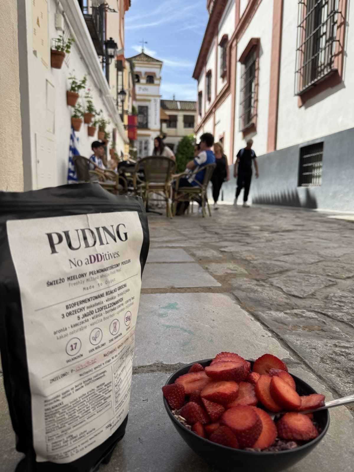 Paczka PUDING na ulicy w Sewilli, w tle przechodnie