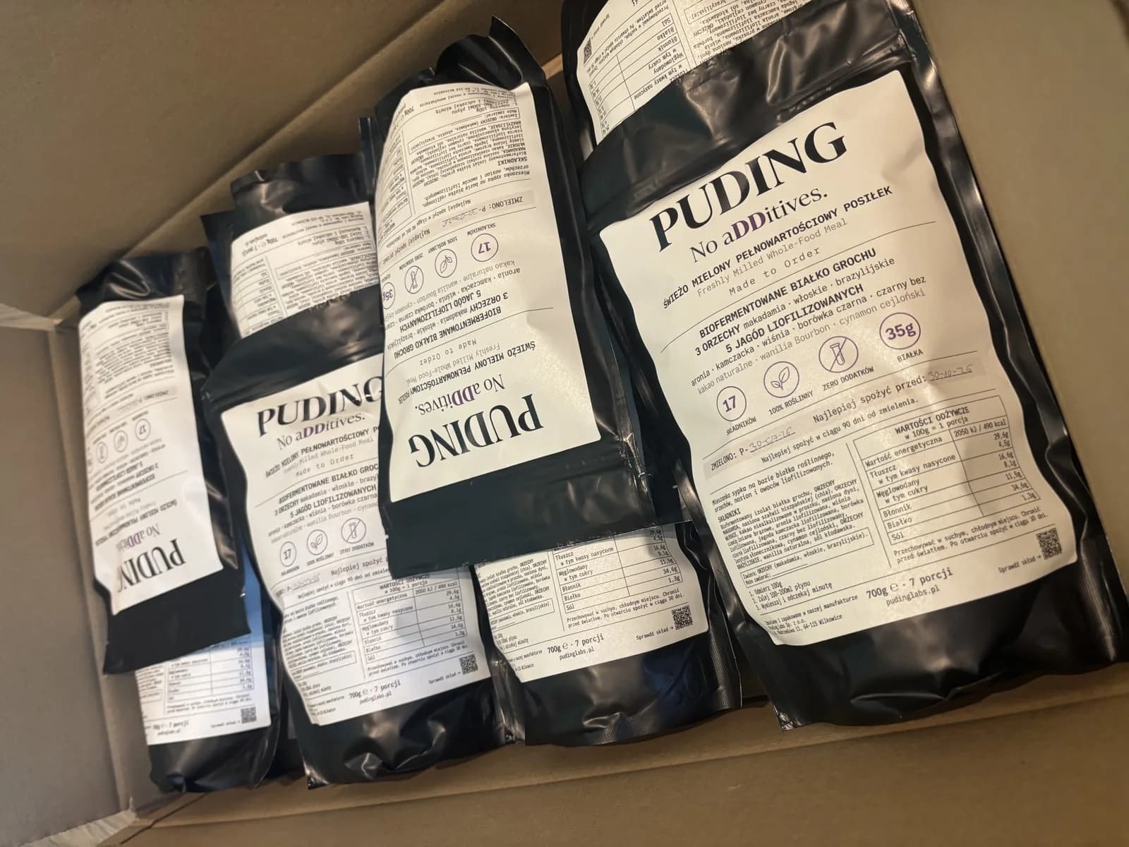 Karton z pięcioma doypackami PUDING, na etykietach ręcznie wpisane numery partii